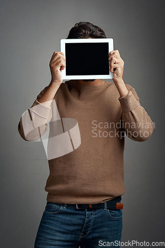 Image of Tablet screen, space and man covering face in studio isolated on a gray background. Touchscreen, hiding and male person with mockup for marketing, advertising and technology for commercial promotion.