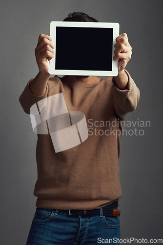 Image of Space, tablet screen and man covering face in studio isolated on a gray background. Touchscreen, hiding and male person with mockup for marketing, advertising and technology for commercial promotion.