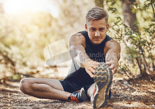 Image of Man is stretching legs, running in forest and fitness with cardio, workout and training outdoor. Young male athlete, runner with warm up and ready to start run, exercise in nature with sport shoes