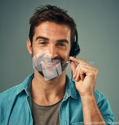 Image of Happy man, headphones and portrait of a call center consultant against a grey studio background. Face of friendly male consulting agent smiling with headset in contact us, customer service or advice