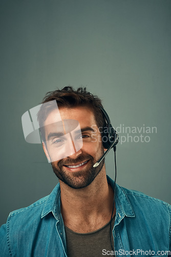 Image of Happy man, call center and consultant with headphones on mockup space against grey studio background. Portrait of friendly male consulting agent with smile and headset in contact us for online advice