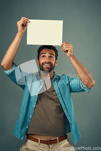 Image of Happy man, poster and mockup billboard for advertising, marketing or branding against a grey studio background. Male person holding blank shape placard or board for sign, message or advertisement