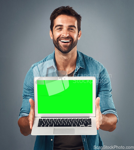 Image of Happy man, laptop and portrait with mockup green screen for advertising or marketing against grey studio background. Male person showing computer display, chromakey or mock up space for advertisement