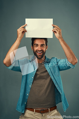 Image of Happy man, portrait and mockup billboard for advertising, marketing or branding against a grey studio background. Male person holding rectangle poster, placard or board for sign or advertisement