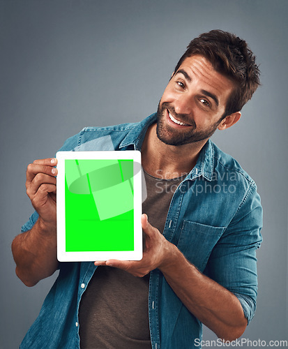 Image of Happy man, portrait and tablet with green screen for advertising, marketing or branding against a grey studio background. Male person showing technology display, chromakey or mock up in advertisement