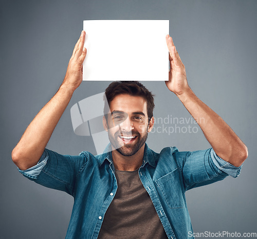 Image of Happy man, portrait and poster on mockup for advertising, marketing or branding against a grey studio background. Male person holding rectangle billboard or placard for sign, message or advertisement
