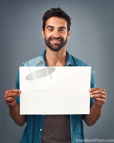 Image of Happy man, portrait and billboard on mockup for marketing, advertising or branding against a grey studio background. Male person holding rectangle poster or placard for sign, message or advertisement