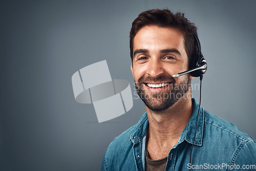 Image of Happy man, call center and headphones on mockup space for consulting against a grey studio background. Portrait of friendly male consultant agent with smile and headset in contact us or online advice