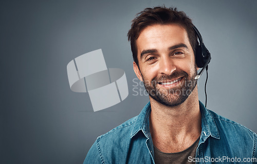 Image of Happy man, call center and headphones for consulting on mockup space against a grey studio background. Portrait of friendly male consultant agent with smile and headset in contact us or online advice