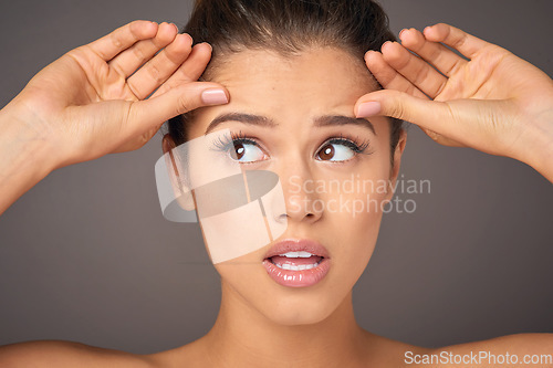 Image of Stress, beauty and a woman with face wrinkles isolated on a dark background in a studio. Concern, worry and a young girl frustrated with skincare, filler and a facial botox cosmetics mistake