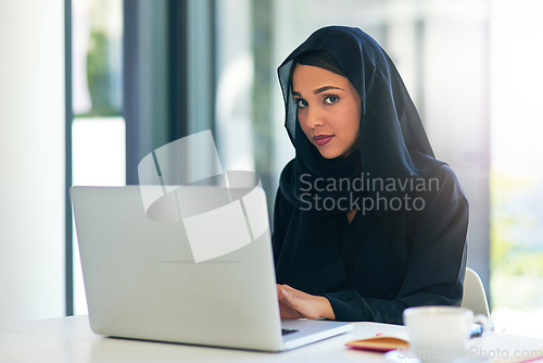 Image of Muslim, portrait and businesswoman working on a laptop for a career in dubai for a company. Woman, arab and professional is an entrepreneur on a computer for web design on a website for a job.