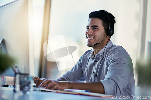 Image of Customer support agent, smile and man in office consulting with advice, crm and happiness at work. Happy phone call, conversation and telecom help desk consultant speaking into headset at computer.