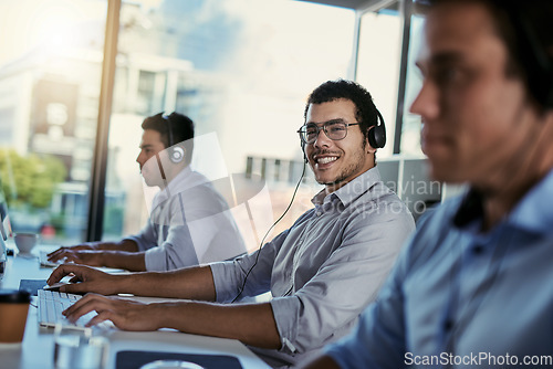 Image of Customer service, smile and coworking, portrait of happy man consulting with advice, computer and team at help desk. Phone call, conversation and happiness, callcenter consultant in modern office.