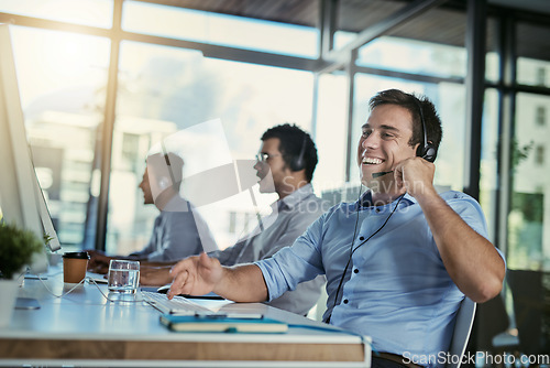 Image of Call center, customer care or service and a man consultant laughing for funny support or assistance on the phone. Smile, crm and contact us with happy male telemarketing agent in his office for help