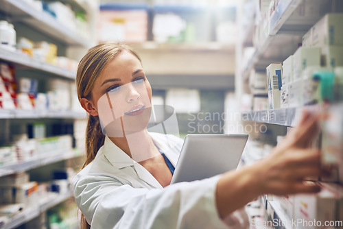 Image of Medicine, woman pharmacist with tablet and looking for prescription in an isle at the pharmacy or clinic. Healthcare, pharmaceutical and female person search for medication with digital device