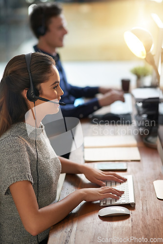 Image of Call center, smile and typing with woman at computer for customer service, help desk or consulting. Happy, advisory and ecommerce with employee in office for contact us, telemarketing or receptionist