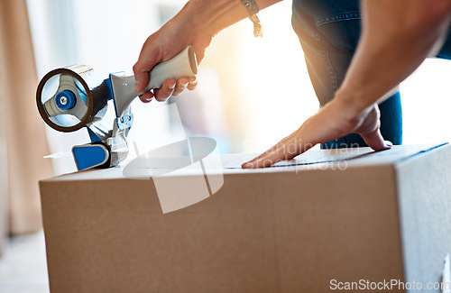 Image of Closeup, cardboard and man with tape, box and move with items, home and shipping parcel. Zoom, male person and guy with tool, seal package or hands with products, closing or relocation with property