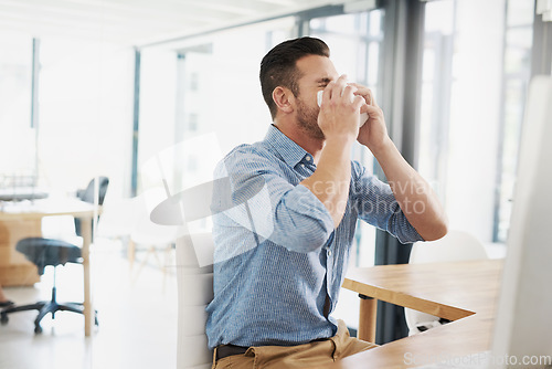 Image of Business man, blowing nose and allergy in office with flu, virus and tissues for healthcare at desk. Young businessman, allergies or sick with hayfever, toilet paper and cleaning mucus in workplace