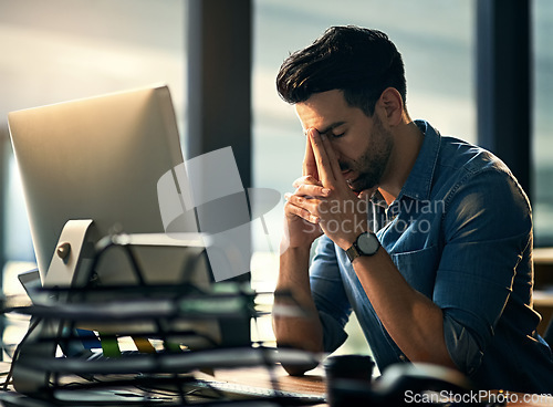 Image of Stress, headache and tired with a business man in his office, sitting eyes closed at his desk for a deadline. Night, burnout and exhausted with a young male employee struggling with pain at work