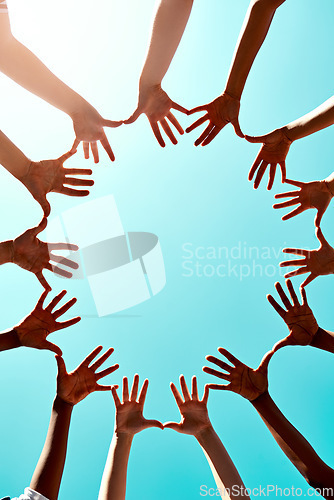 Image of Community, support with hands in air and in blue sky outdoors for unity. Diversity or collaboration, sunlight and group of people with their hand in a circle for solidarity or trust with lens flare