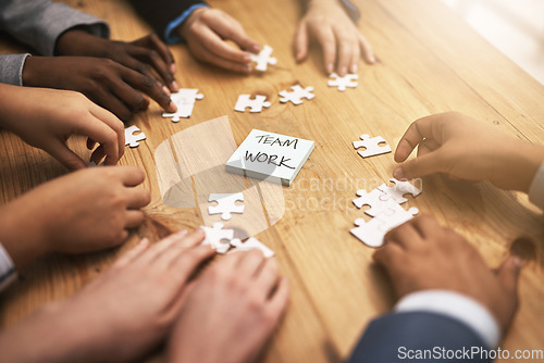 Image of Teamwork, puzzle and hands of business meeting for brainstorming in a meeting together planning strategy at work. Circle, jigsaw and professional group of people at a table working on innovation