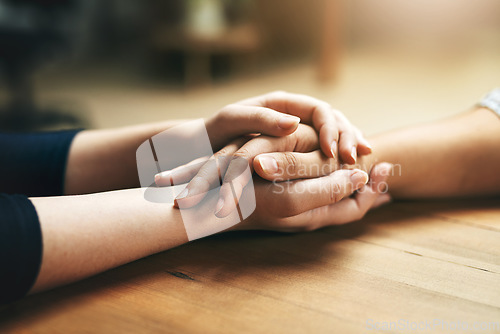 Image of Holding hands, comfort and support of friends, care and empathy together on table in home mockup. Kindness, love and women hold hand for hope, trust or prayer, solidarity or compassion, help or unity