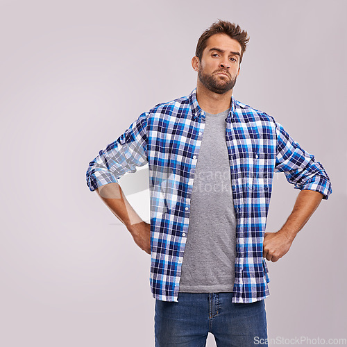 Image of Frustrated, angry and portrait of a man unsure in a studio feeling annoyed and moody. Isolated, gray background and young male model with upset person face and grumpy with from fail and problem