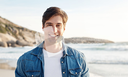 Image of Man, portrait and beach with sunshine and smile in the outdoors for an adventure and happiness. Ocean, sun and male person is happy in the outdoor for day to relax in the summer with nature and air.