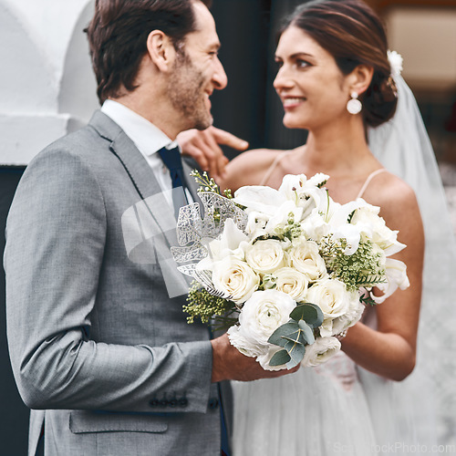 Image of Flowers, wedding and love with a married couple standing outdoor together after a ceremony of tradition. Love, marriage or commitment with a man and woman outside looking happy as husband and wife