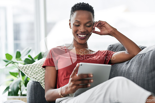 Image of Digital tablet, happy and black woman relax on a sofa for social media, reading and browsing blog in her home. Smile, online and African female person on couch with ebook, streaming or subscription