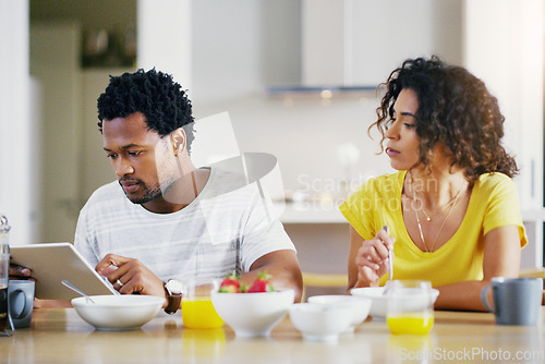Image of Tablet, breakfast and couple in kitchen online for social media, internet and app in morning. Marriage, love and curious woman looking at man on digital tech for website browse, search and network