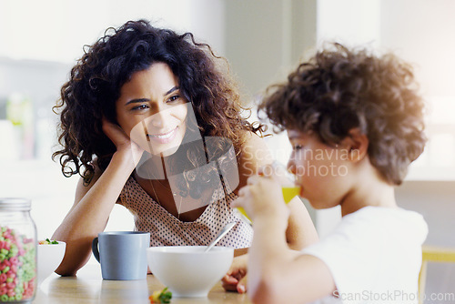 Image of Family, breakfast and kid with mother in a home with happiness and orange juice with care. Mom, food and young child together with parent love and support with healthy drink and youth with a smile