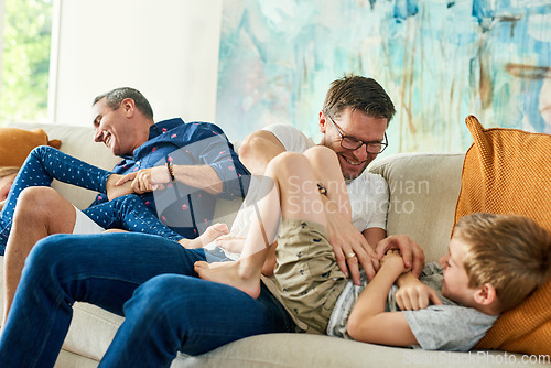 Image of Gay parents, family and tickling in living room with dads and kids together with laugh. Parent love, bonding and care with father, papa and children in a home with a smile or fun lgbt people in house