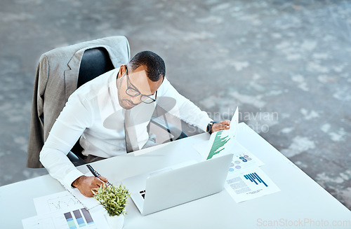 Image of Financial analyst, focus and black businessman writing in his office space or reading data report and employee on desk. Statistics, stock market and corporate worker with graphs or laptop on mockup