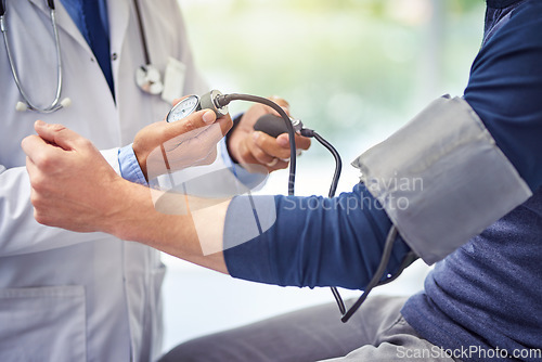 Image of Check up, doctor and man patient for blood pressure test at a hospital with lens flare. Consultant or medical workers, health wellness and nurse with male person for healthcare exam at a clinic