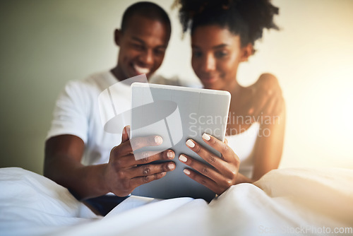 Image of Tablet, bedroom and happy couple in home with movie, video or communication on social media app. Black man, woman and digital touchscreen in house with reading, online chat or smile at meme together