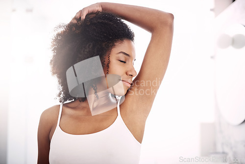 Image of Happy African woman, smelling armpit and bathroom in home with fragrance, clean and morning routine. Girl, hygiene and grooming with cleaning, fresh scent and check for self care, wellness or health