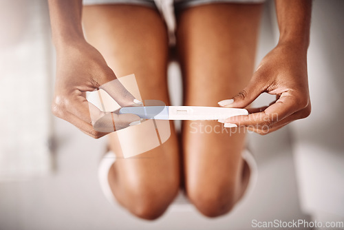 Image of Hands, healthcare and closeup of a woman with a pregnancy test in the bathroom of her home. Maternity, motherhood and zoom of female person with pregnant stick device for announcement in modern house