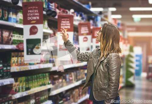 Image of Shopping, woman at grocery store and in aisle searching and decision for product on a shelf. Customer or consumer, shopper for groceries and female person at supermarket or a shop looking for food