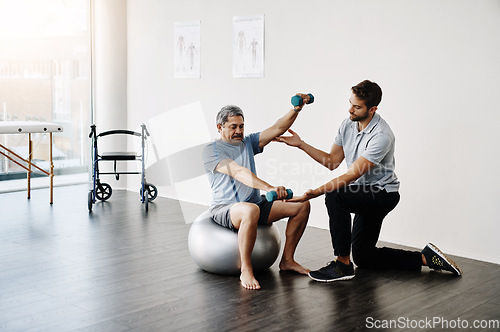 Image of Dumbbells, physiotherapy and balance with doctor and old man for rehabilitation, training and stretching. Healthcare, wellness and healing with patient and expert for consulting, muscle and exercise