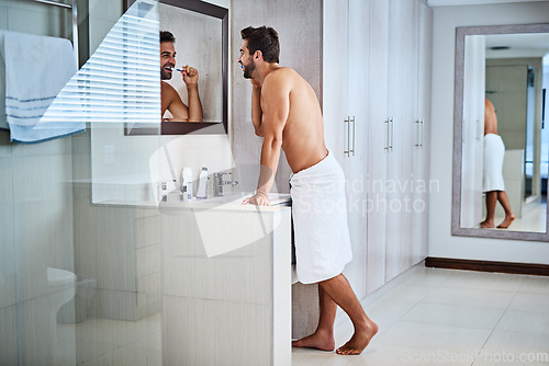 Image of Man brushing teeth in bathroom at mirror for dental wellness, healthy habit and gums. Shirtless guy, shower and cleaning mouth for fresh breath, oral hygiene and morning routine for grooming at home