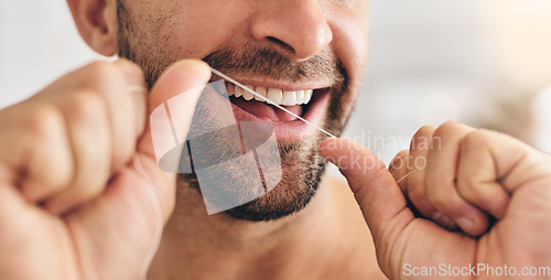 Image of Closeup, face and man flossing teeth at home for healthy dental wellness, plaque and gingivitis. Happy guy, oral thread or cleaning mouth for fresh breath, tooth hygiene and habit to care for smile