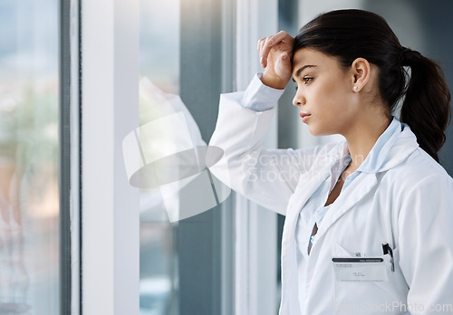 Image of Thinking, stress and doctor by window in hospital with worry, anxiety and tired with headache in clinic. Healthcare, mental health and woman health worker with stressed out, depression and burnout