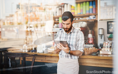 Image of Tablet, business owner and man in a coffee shop doing inventory while working on a startup plan in a restaurant. Cafeteria, entrepreneur and male barista doing research on digital technology in cafe.