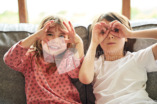 Image of Portrait, siblings and sisters on a couch, funny and facial expression with happiness, bonding and loving. Face, female children or young people with joy, silly and goofy with a smile, home and relax