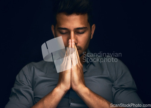 Image of Night, worship and man with hands praying in studio to God, Jesus Christ or spiritual healing on black background. Holy, gratitude and thank you by christian male in prayer for help, hope and trust