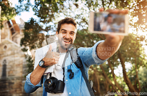 Image of Happy man, tourist and thumbs up selfie outdoor in a city for travel with holiday memory, smile and happiness. Male person on adventure, journey with sign for vacation photo and freedom with backpack