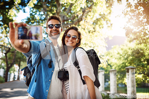 Image of Selfie, happy couple and outdoor for travel with a smile for holiday memory and happiness. Man and woman at a park with trees for adventure, journey or vacation photo and freedom with love and care