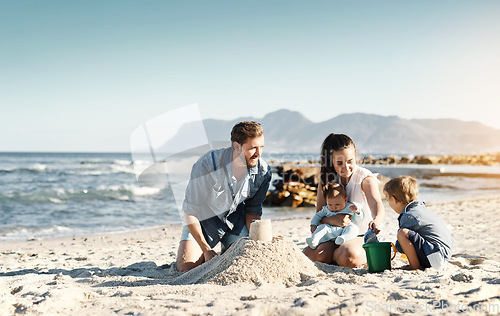 Image of Sandcastle, happy summer and children at the beach with bonding, love and support. Baby, mom and dad together with kids playing in the sun with mockup space and smile by the ocean and sea with family