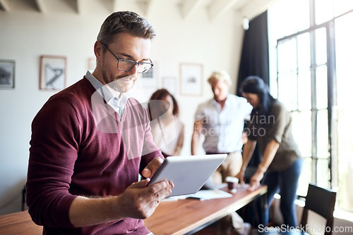 Image of Man, tablet and working in office meeting with team in creative workspace and planning, research and management. Businessman, happy teamwork and web design leader with technology for project